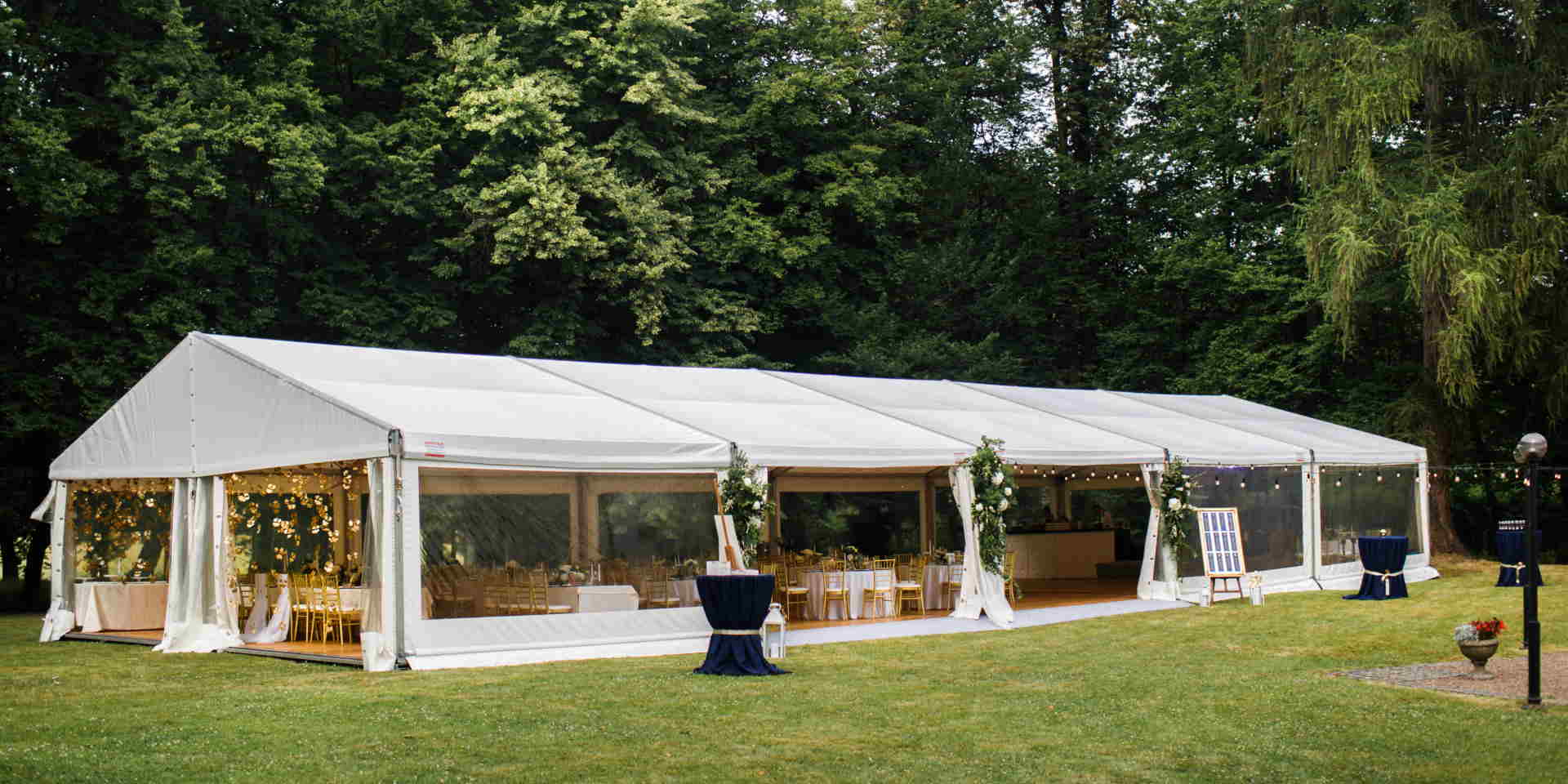 Long white tent for wedding party in the woods. Blackburn Marquees